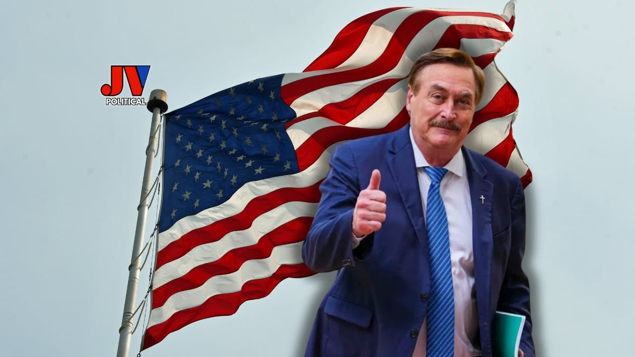 Proud American patriot Mike Lindell stands tall with a thumbs-up, rocking a sharp blue suit and tie, while a massive American flag waves proudly in the background. The JVPolitical logo shines bright, symbolizing the fight for truth and freedom. #Patriotism #Leadership #AmericaFirst #PoliticalCampaign #Election2024 #MAGA #FreedomFighters #Trump2024 #SupportOurHeroes